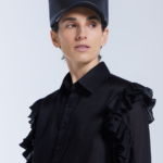 Model wearing KimC Studio sculptural faux leather cap with architectural peaks