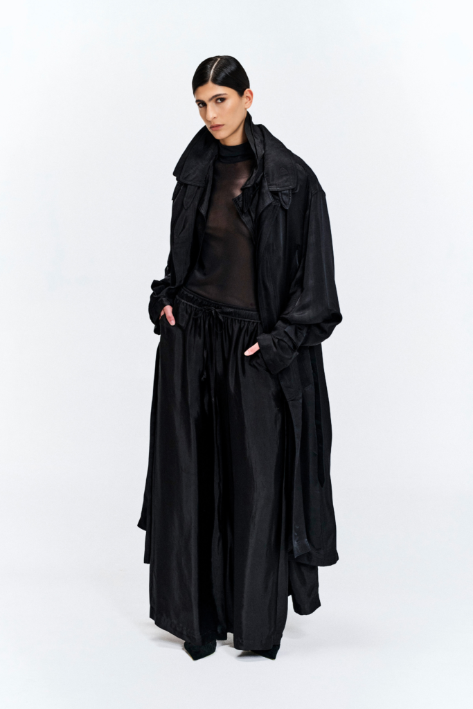 Model wearing a black silk longline coat with a double collar by KimC Studio.