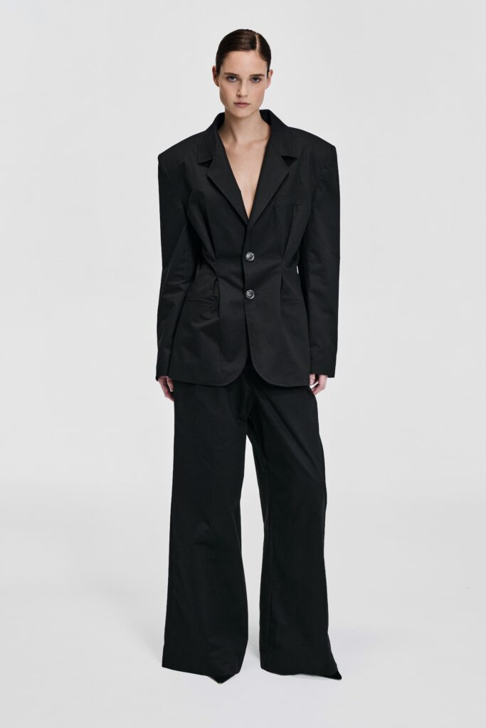 Front view of model wearing a black tailored blazer with structured shoulders and waist-defining shaping by KimC Studio.