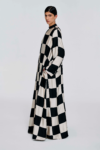 Model wearing a black and white checked floor-length dress with long sleeves and a stand collar by KimC Studio.