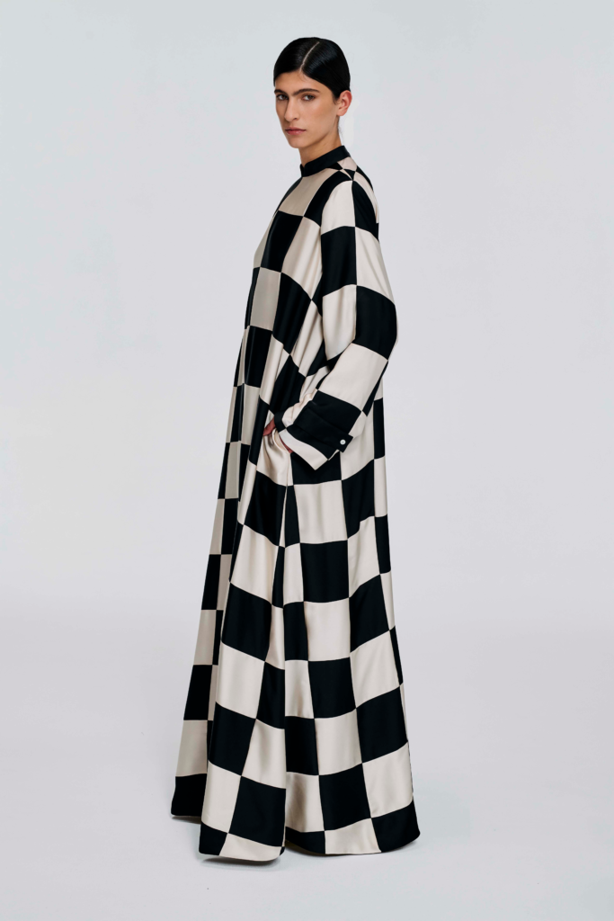 Model wearing a black and white checked floor-length dress with long sleeves and a stand collar by KimC Studio.