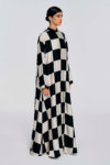 Model wearing a black and white checked floor-length dress with long sleeves and a stand collar by KimC Studio.