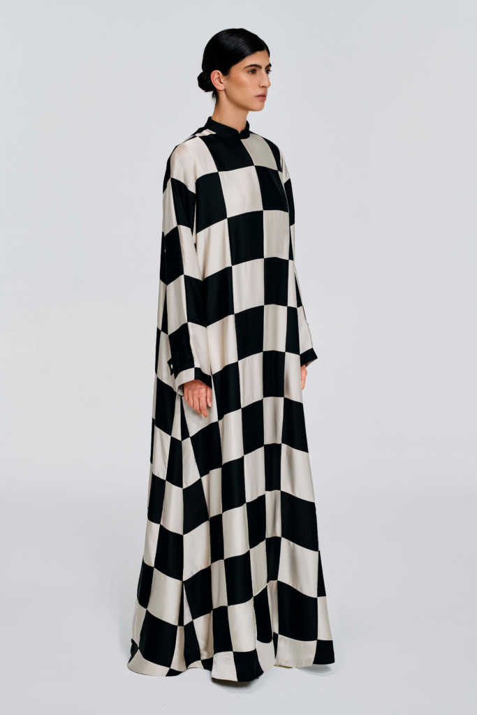 Model wearing a black and white checked floor-length dress with long sleeves and a stand collar by KimC Studio.