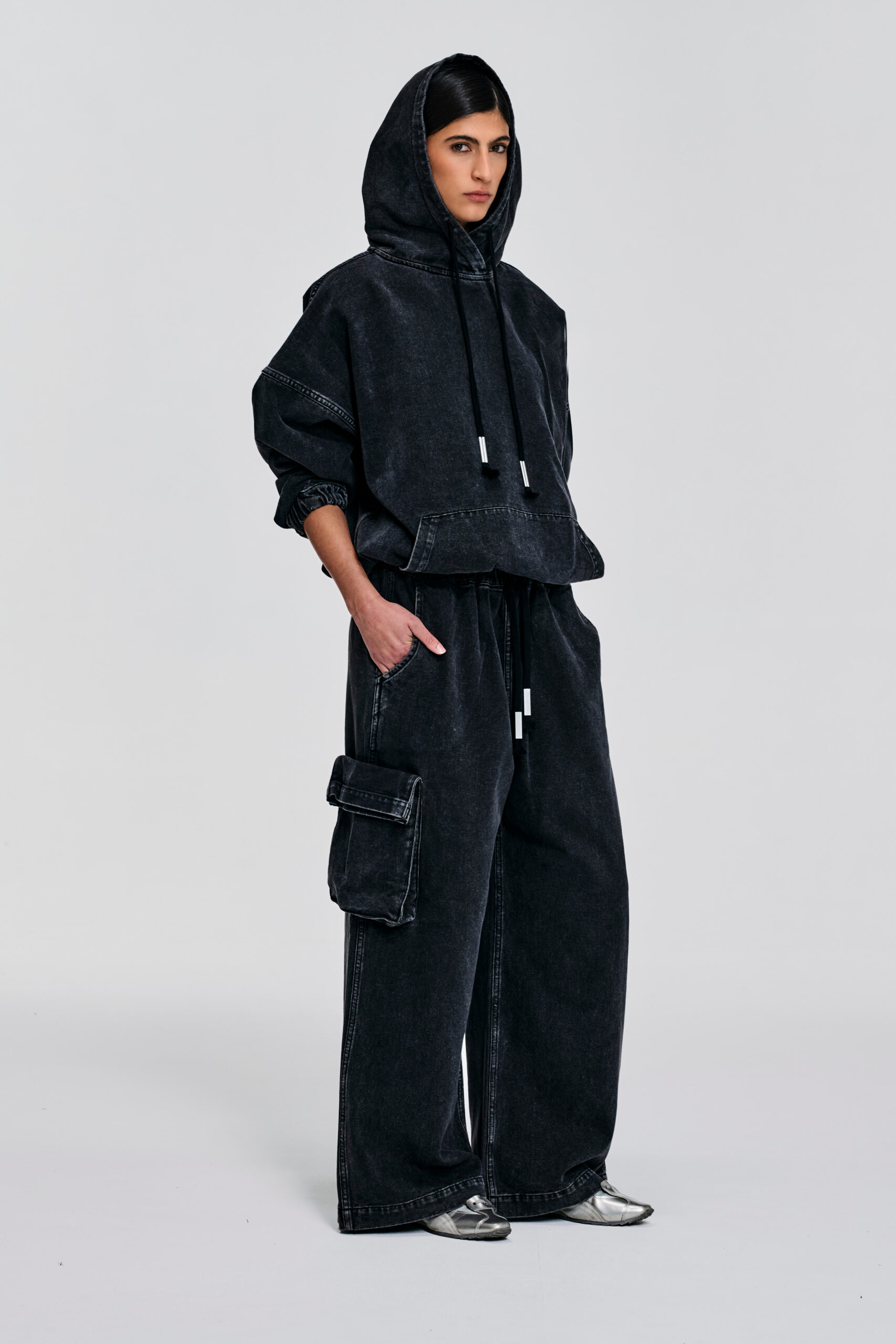 Enzyme-washed black denim hoodie with oversized fit, dropped shoulders, cropped hem, hood ties, and contrast stitching by KimC Studio.