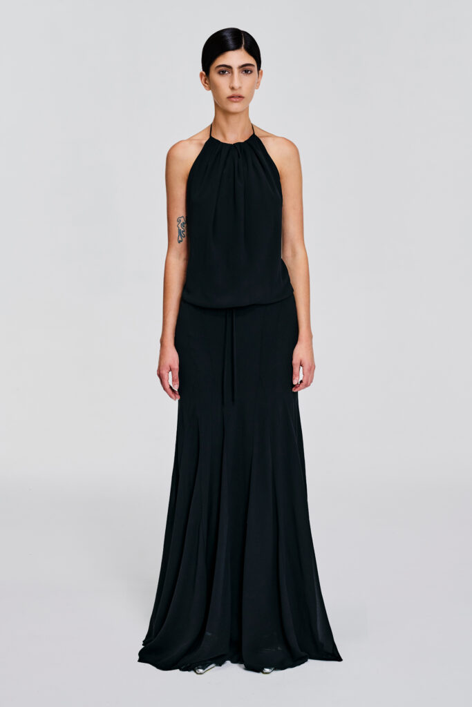 Model wearing a gathered halter maxi dress with relaxed blouson bodice, adjustable waist tie, satin lining and bias-cut floor-length skirt by KimC Studio.