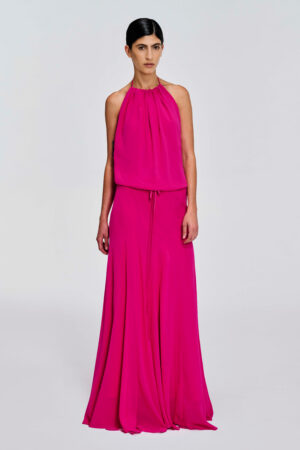 Model wearing a gathered halter maxi dress with relaxed blouson bodice, adjustable waist tie, satin lining and bias-cut floor-length skirt by KimC Studio.