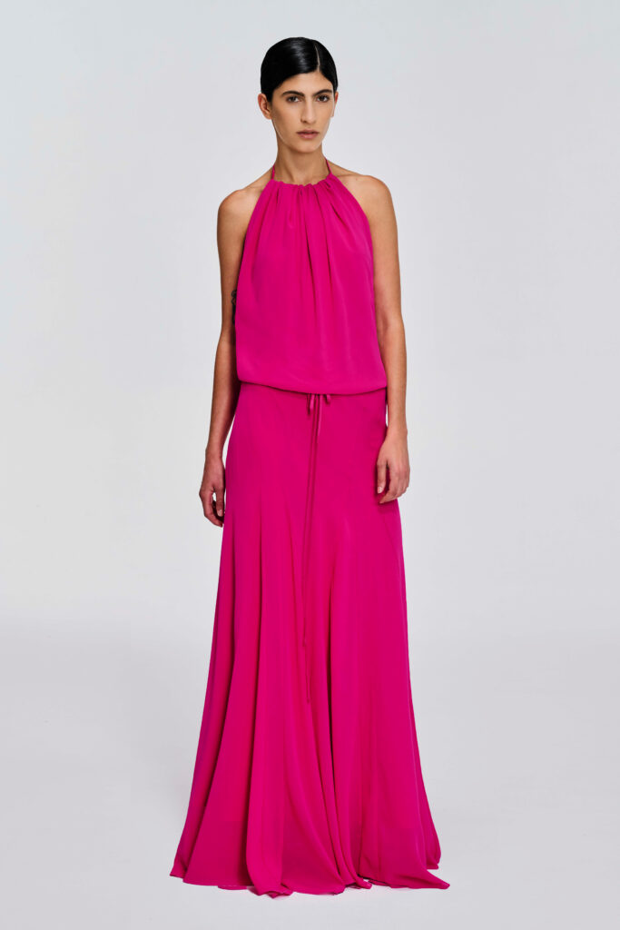 Model wearing a gathered halter maxi dress with relaxed blouson bodice, adjustable waist tie, satin lining and bias-cut floor-length skirt by KimC Studio.