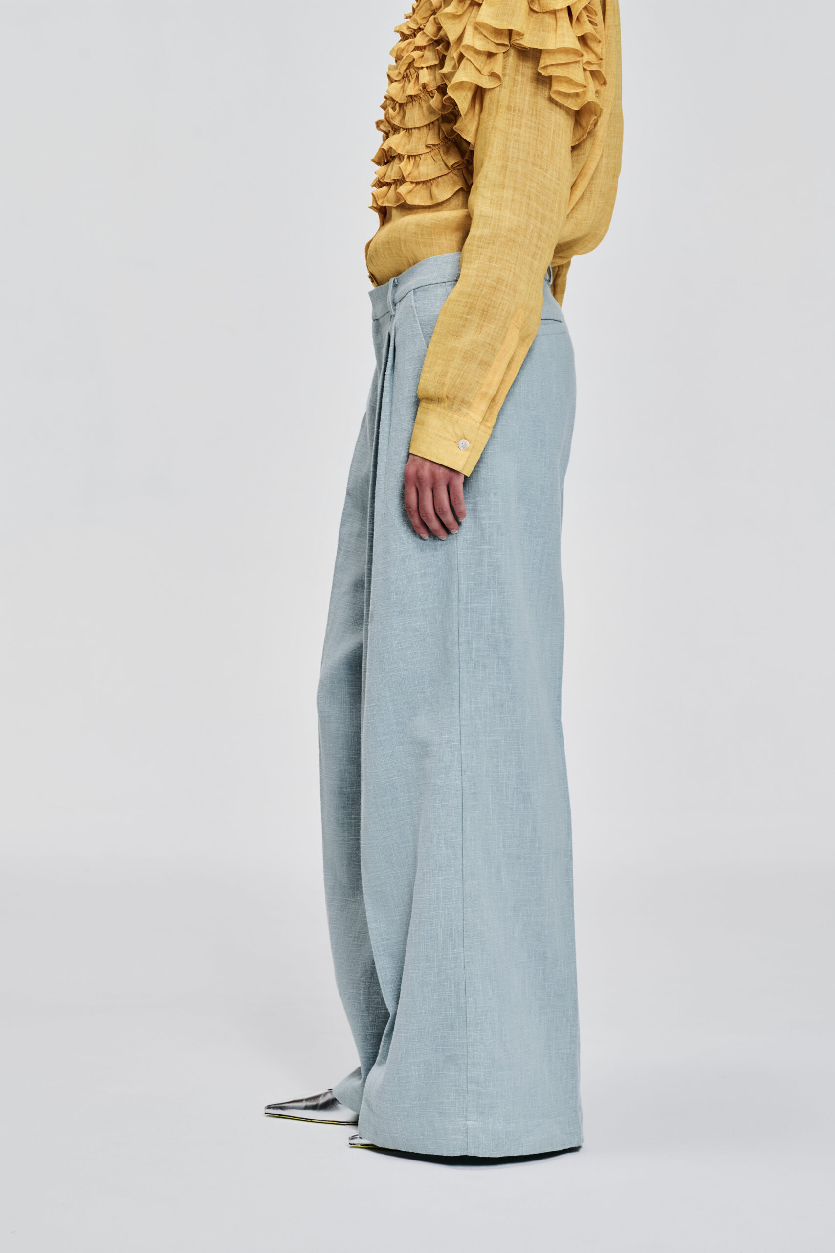 Model wearing pale blue wide-leg linen pants by KimC Studio.