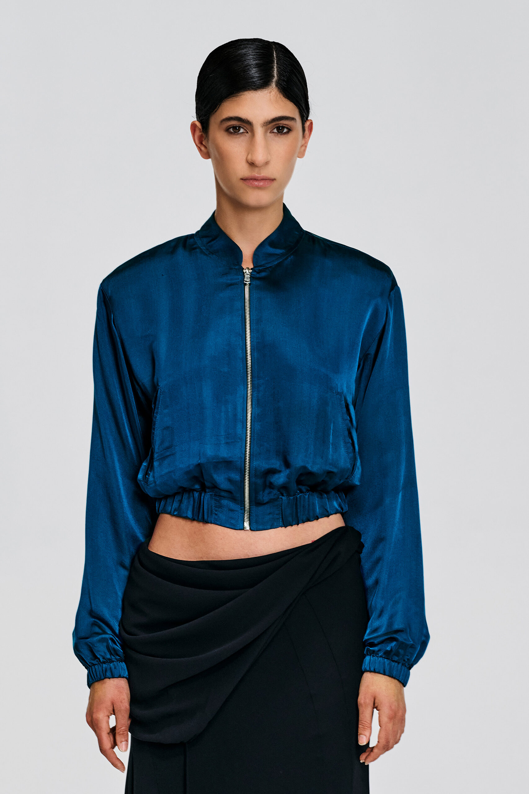 Deep teal silk cropped bomber jacket by Kim C Studio, front view.