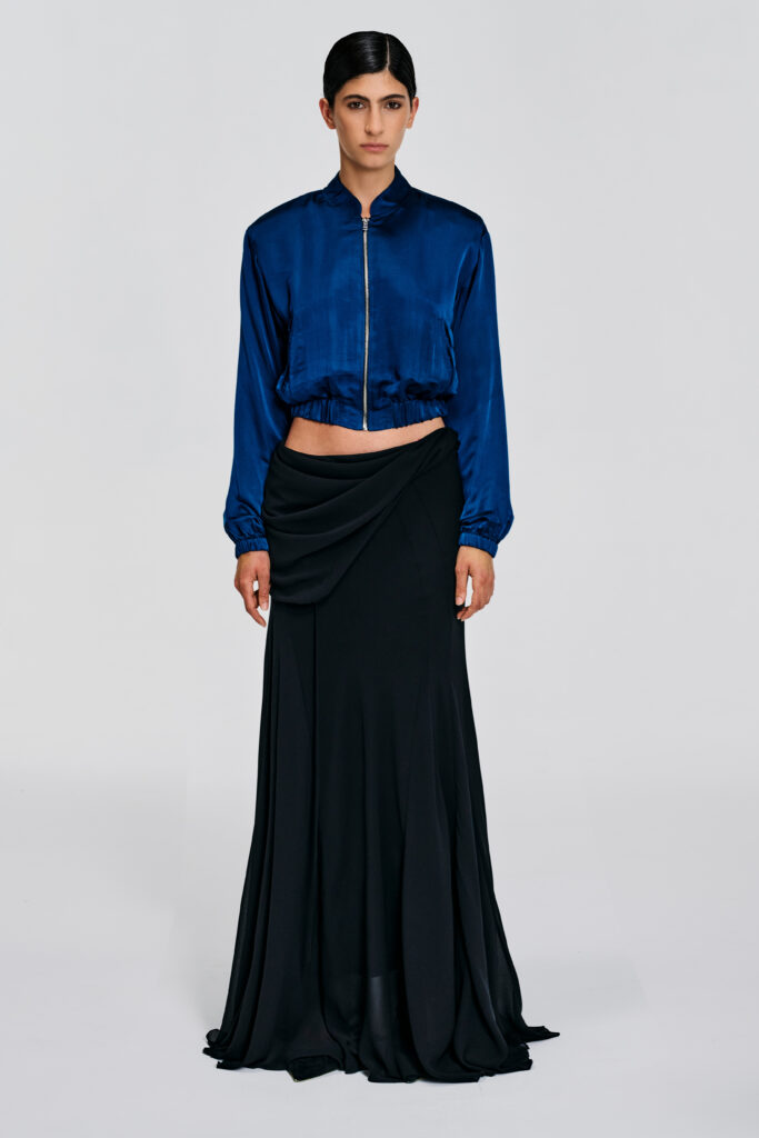 Model wearing a deep teal silk cropped jacket with silk lining, zip front, standing neckline, and elasticated hem by KimC Studio.
