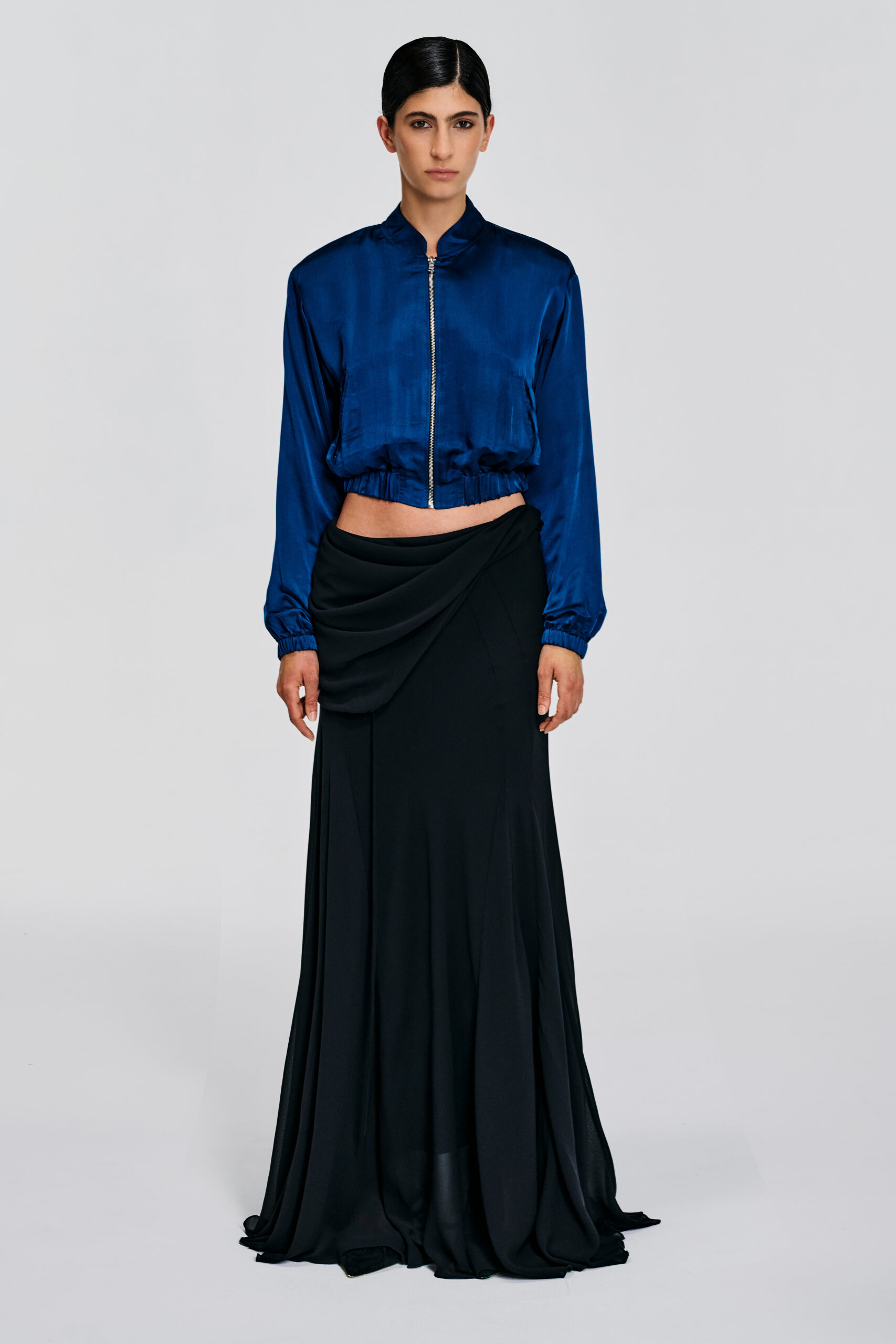Model wearing a deep teal silk cropped jacket with silk lining, zip front, standing neckline, and elasticated hem by KimC Studio.