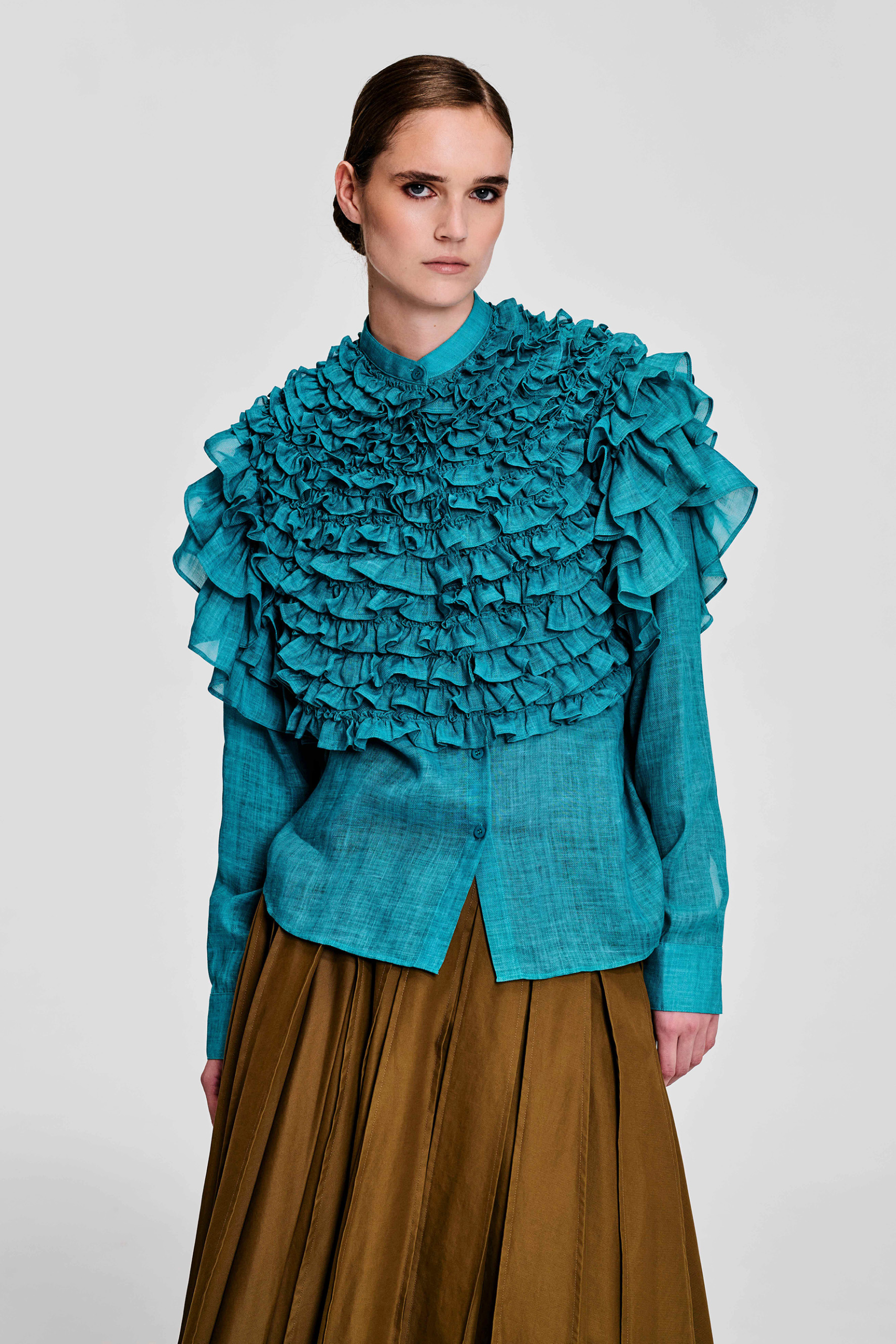 Model wearing a turquoise ruffle hemp blouse with layered ruffle detailing by KimC Studio.