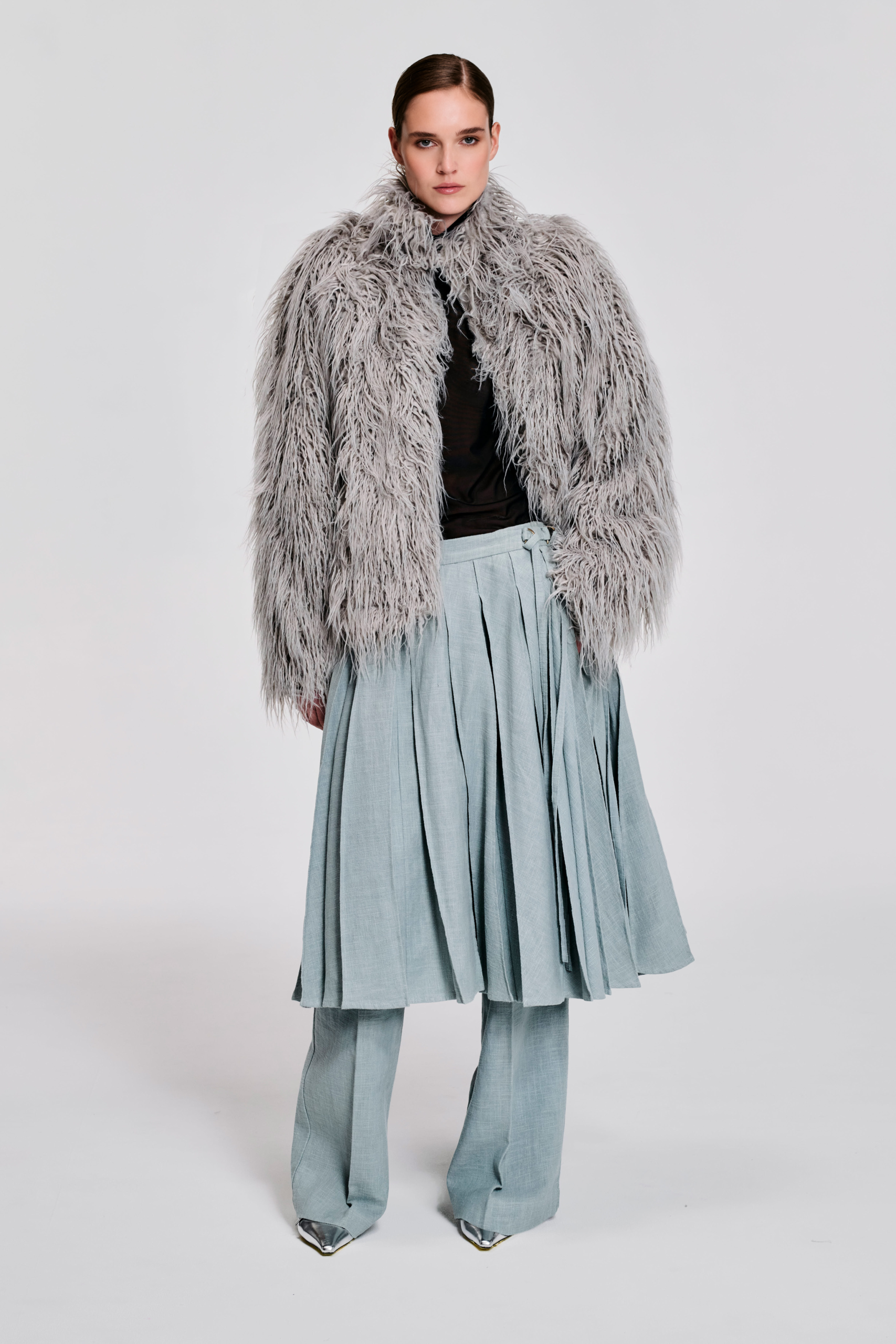 Model wearing an oversized grey faux fur jacket with zip front and drawstring hem by KimC Studio.