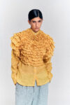 Model wearing a yellow ruffle hemp blouse with layered ruffle detailing by KimC Studio.