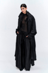Model wearing a black silk longline coat with a double collar by KimC Studio.