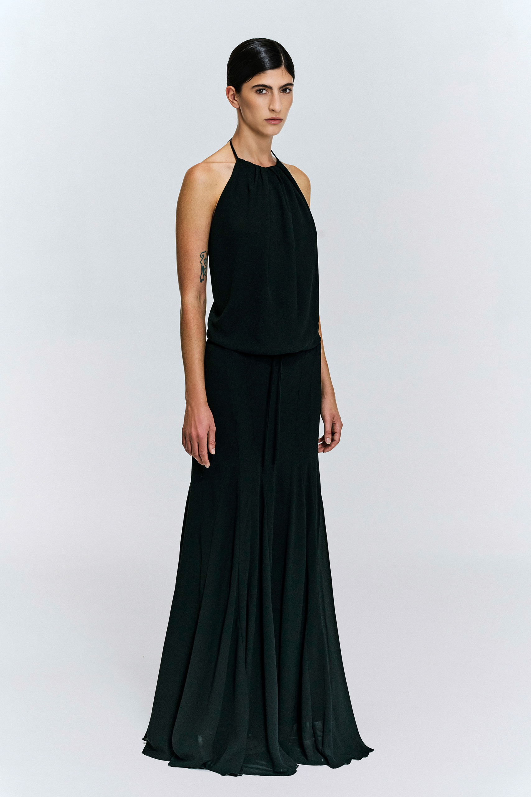 Model wearing a gathered halter maxi dress with