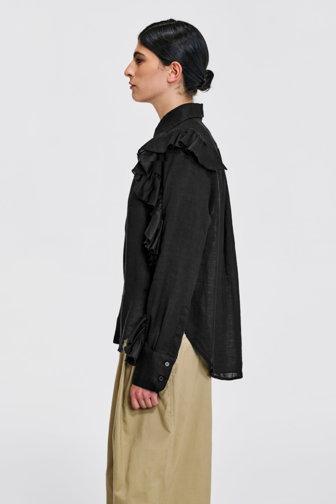 Model wearing KIM C STUDIO black linen ruffle-sleeve shirt