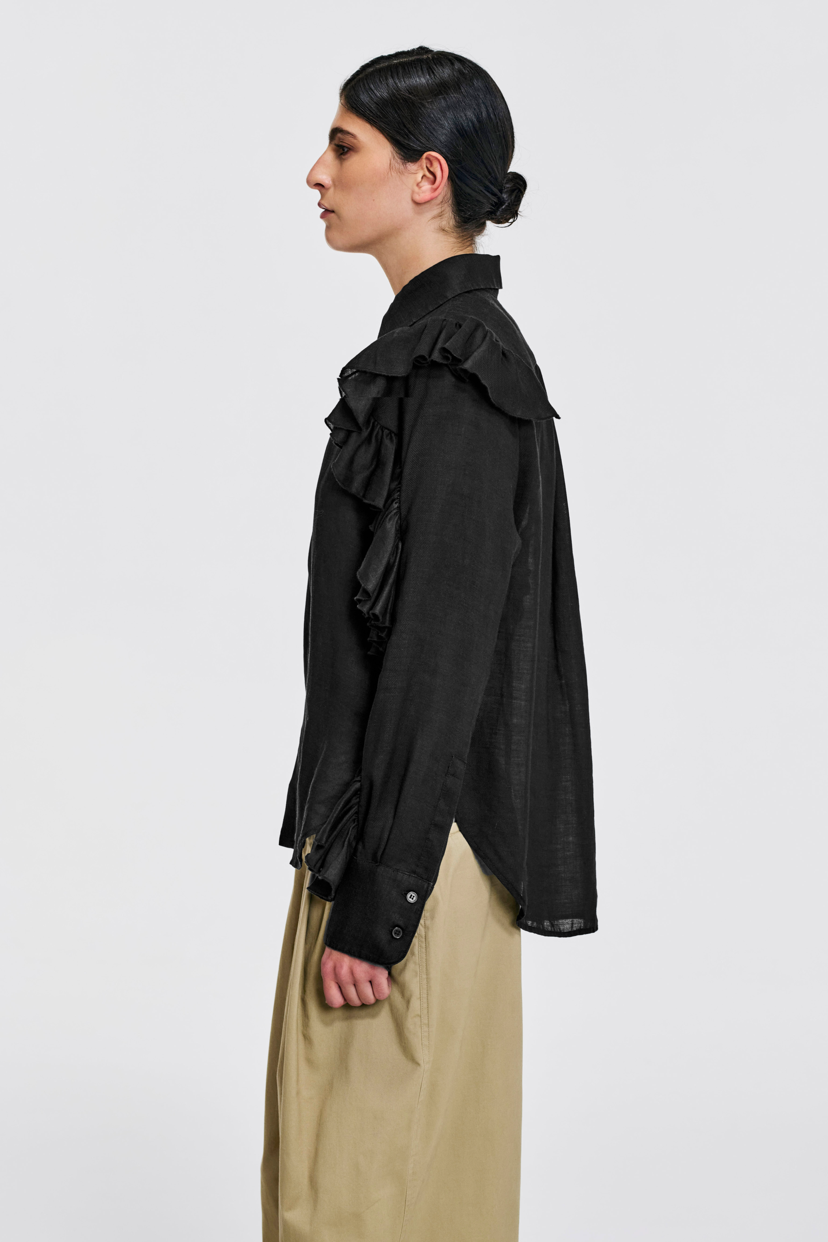 Model wearing KIM C STUDIO black linen ruffle-sleeve shirt