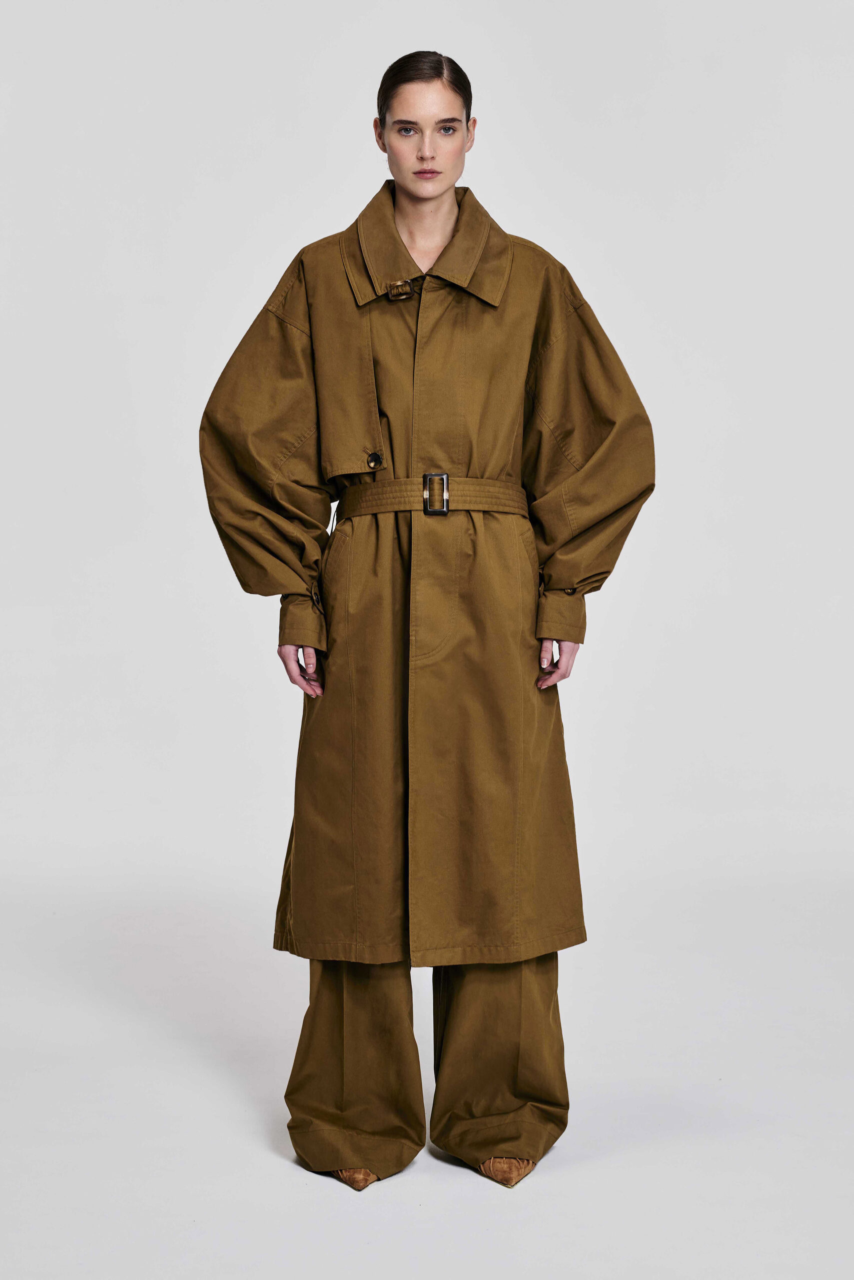 Model wearing the KIM C STUDIO oversized camel cotton trench coat, front view