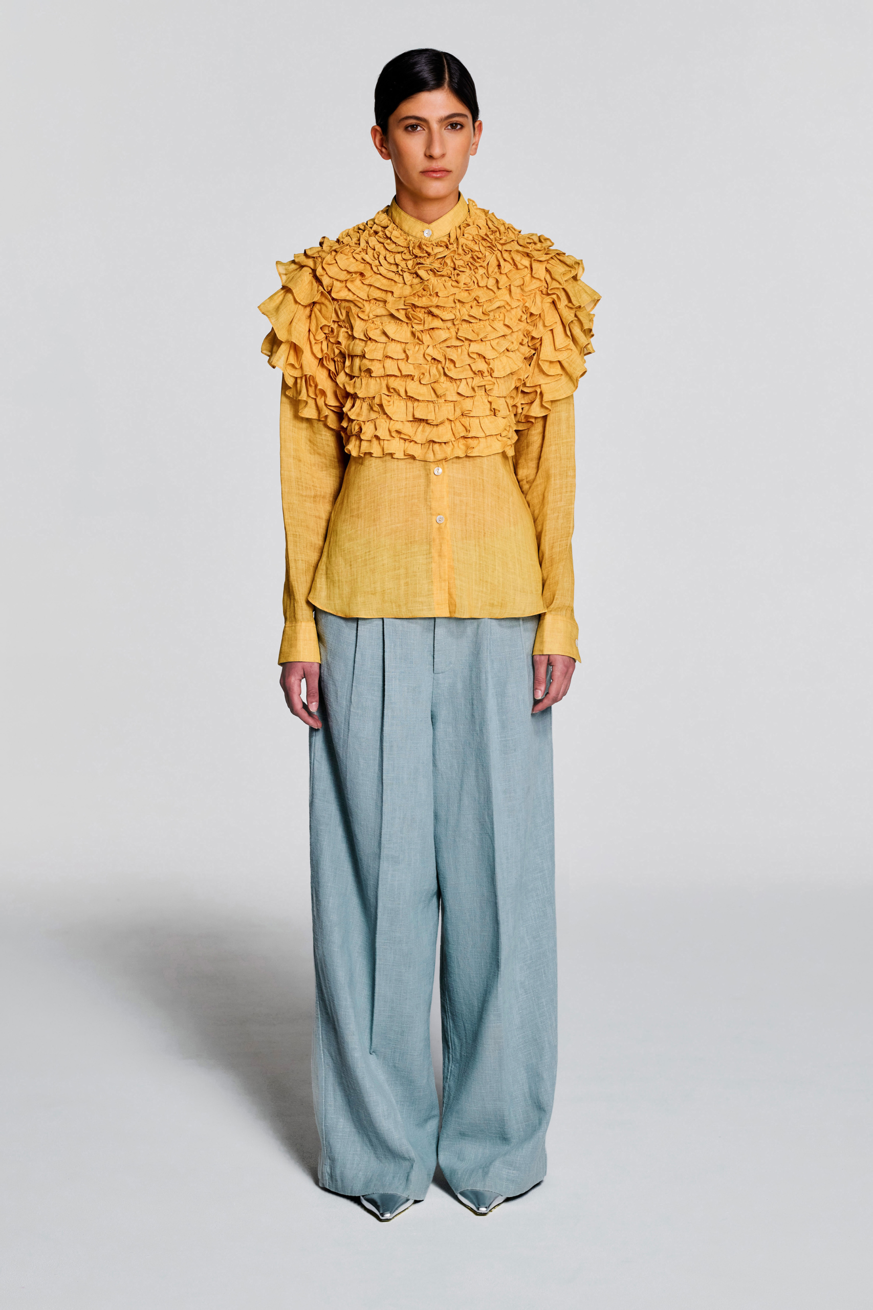 Front view of a model wearing the KIMC STUDIO yellow ruffle hemp blouse