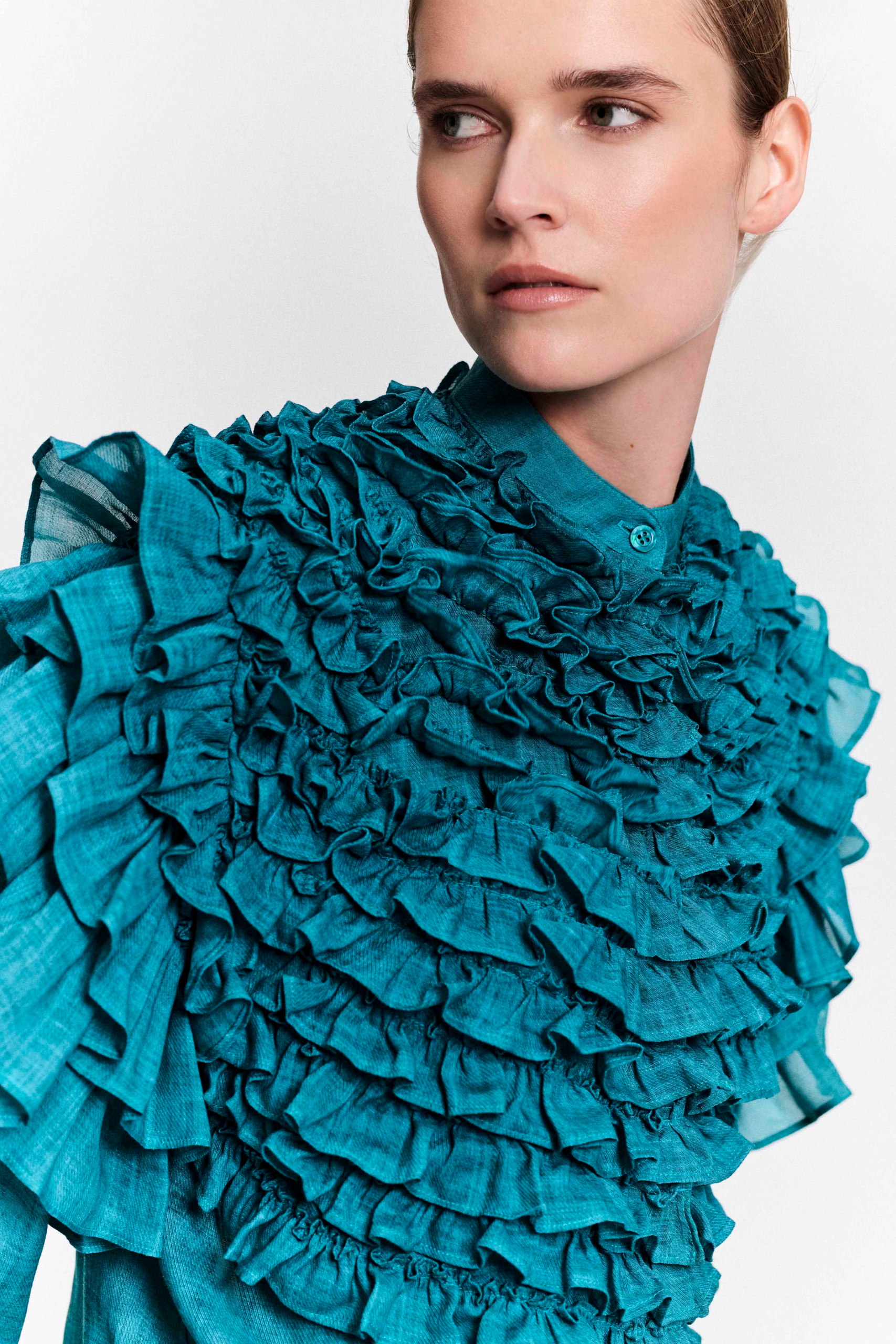 Model wearing a turquoise ruffle hemp blouse by KIMC STUDIO.